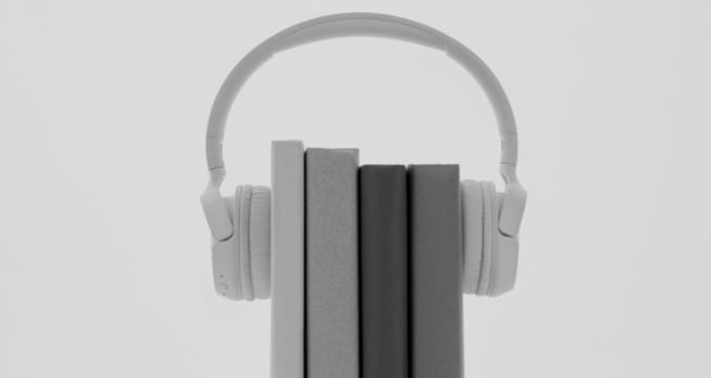 Four books wearing XX59 Headphones