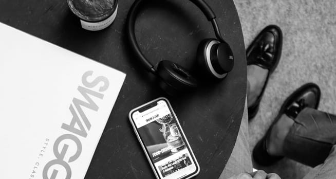 A phone, a magazine, and XX99 Mark II Headphones laying on a table