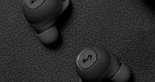 Zoomed in on YX1 Wireless Earphones laying on soft fabric