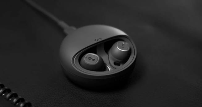 YX1 Wireless Earphones laying in their charging station
